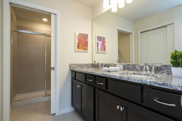 bathroom with tile patterned flooring, vanity, and a shower with door