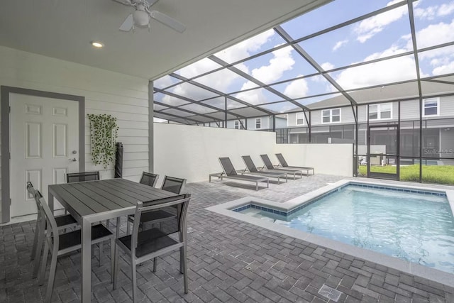 view of pool featuring glass enclosure, ceiling fan, and a patio