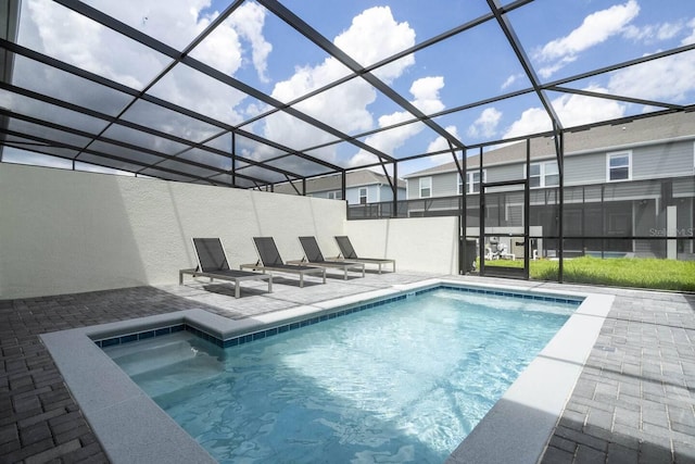 view of swimming pool with glass enclosure and a patio area