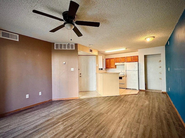 unfurnished living room featuring ceiling fan, a textured ceiling, and light hardwood / wood-style flooring