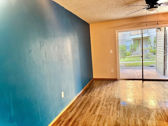 empty room featuring hardwood / wood-style flooring, ceiling fan, and a textured ceiling