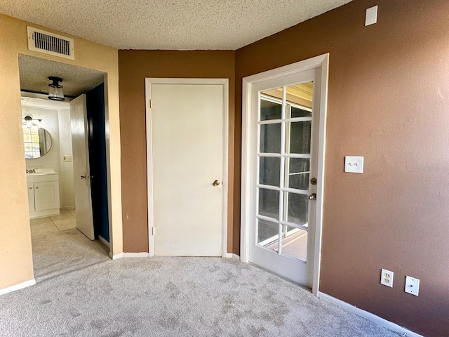 interior space featuring a textured ceiling and light carpet