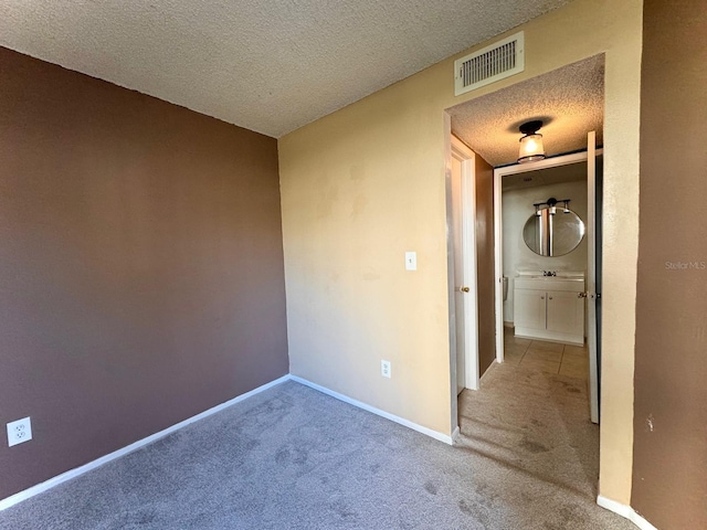 carpeted spare room featuring a textured ceiling