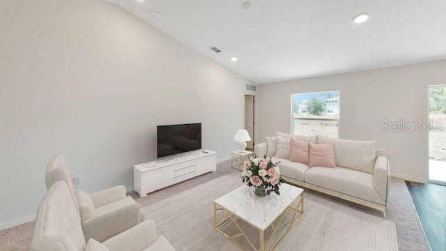 living room with light hardwood / wood-style floors and lofted ceiling