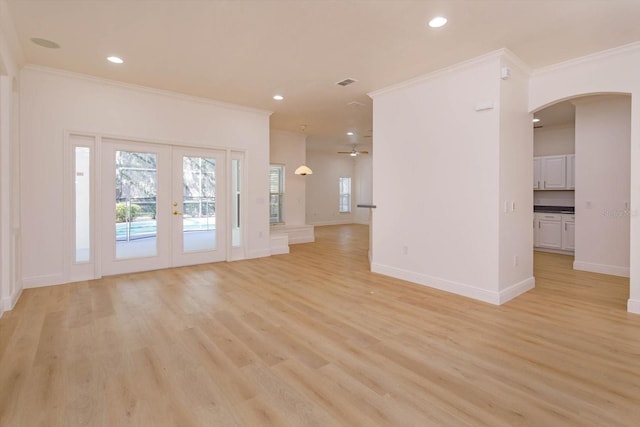 unfurnished living room featuring crown molding, french doors, and light wood-type flooring