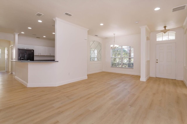 interior space featuring crown molding, a chandelier, and light hardwood / wood-style floors