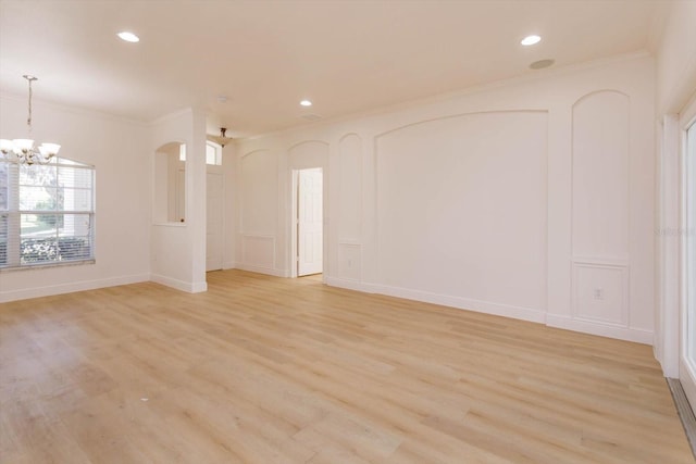 unfurnished room featuring crown molding, an inviting chandelier, and light hardwood / wood-style flooring