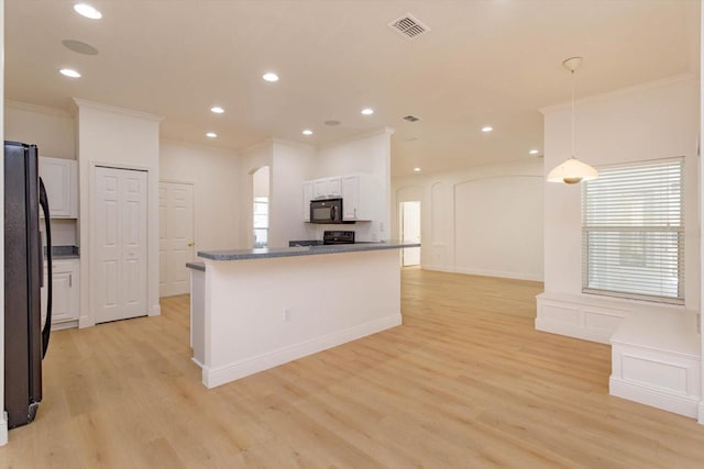 kitchen with white cabinets, hanging light fixtures, ornamental molding, black appliances, and light wood-type flooring