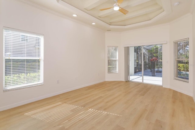 empty room featuring crown molding, ceiling fan, a raised ceiling, and light hardwood / wood-style flooring