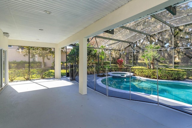 view of pool featuring a patio, glass enclosure, and an in ground hot tub