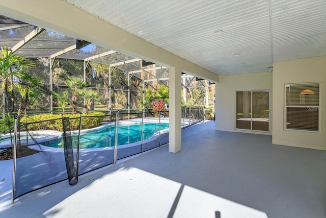 view of pool with a patio area and glass enclosure