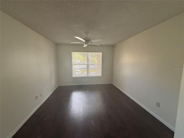 empty room featuring a textured ceiling, ceiling fan, and dark wood-type flooring