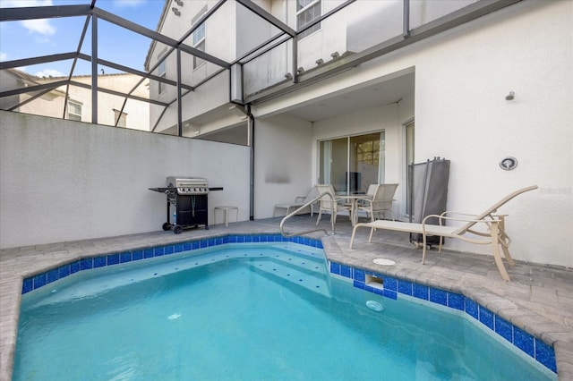 view of pool featuring glass enclosure, area for grilling, and a patio