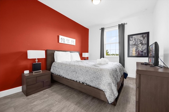 bedroom with hardwood / wood-style flooring and vaulted ceiling