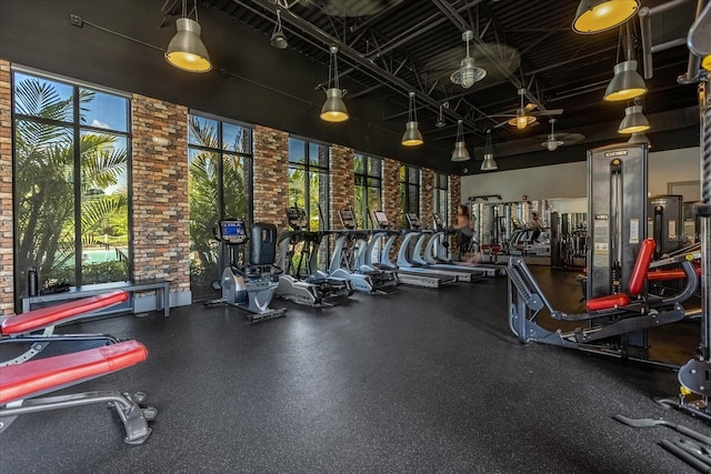 workout area featuring brick wall and a high ceiling