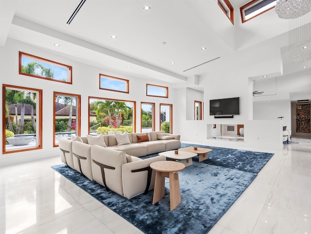 tiled living room with a towering ceiling and a notable chandelier