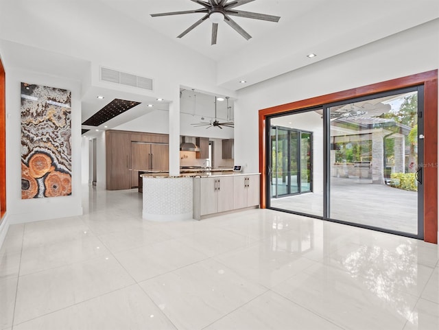 unfurnished living room with ceiling fan and light tile patterned floors