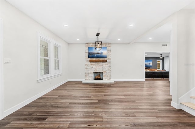 unfurnished living room with a fireplace, hardwood / wood-style flooring, and ceiling fan