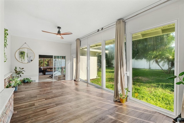 unfurnished sunroom featuring ceiling fan