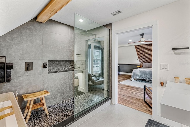 bathroom with tiled shower, beam ceiling, tile patterned floors, and ceiling fan