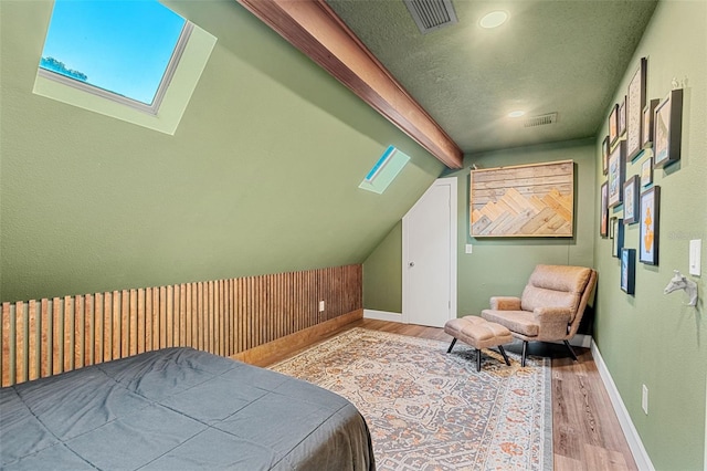 bedroom with light hardwood / wood-style flooring and lofted ceiling with beams