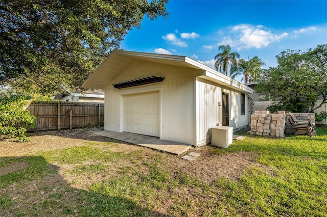 rear view of property featuring a yard, an outbuilding, and a garage