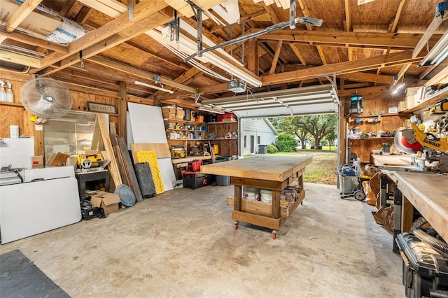 garage with a workshop area, washer / clothes dryer, and a garage door opener