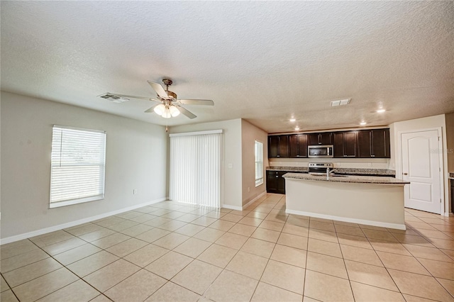 kitchen featuring stainless steel appliances, a kitchen island with sink, sink, and light tile patterned floors