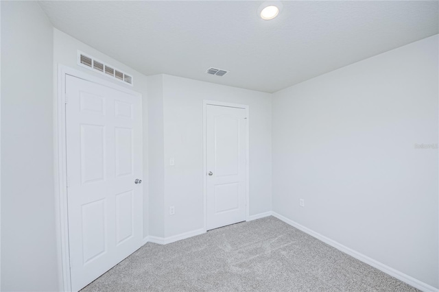 unfurnished bedroom with a closet and light carpet