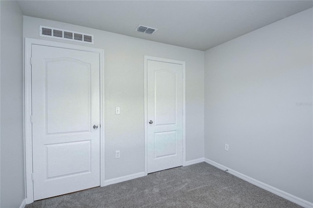 unfurnished bedroom with dark carpet