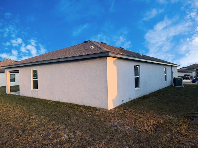 view of property exterior featuring central AC and a lawn