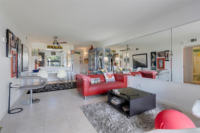 tiled living room with ceiling fan and a textured ceiling