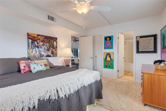 bedroom featuring ceiling fan, a closet, light carpet, and ensuite bath