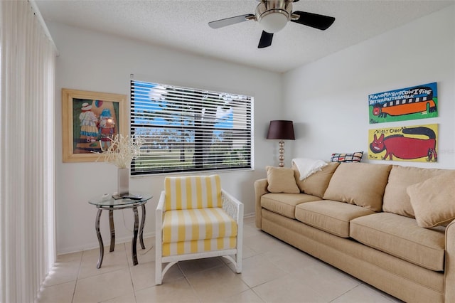 living room featuring light tile patterned floors, a textured ceiling, and ceiling fan