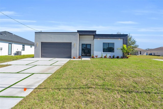 contemporary home with a garage, a front yard, and central air condition unit