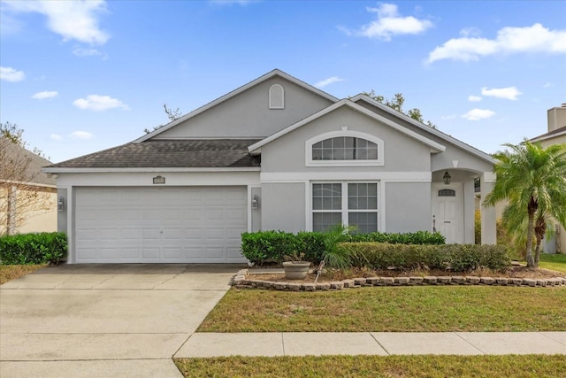 view of front of house featuring a garage and a front lawn