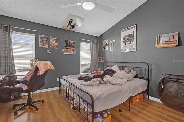 bedroom with multiple windows, light hardwood / wood-style floors, vaulted ceiling, and ceiling fan