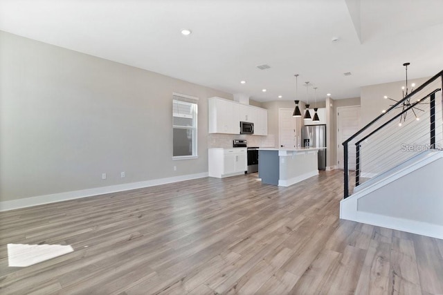 living room featuring light wood-type flooring and a notable chandelier