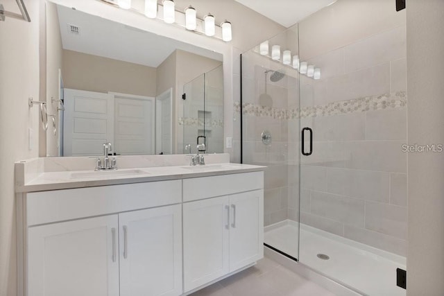 bathroom with vanity, tile patterned floors, and a shower with door