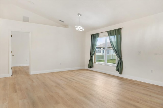 empty room with light wood-type flooring and lofted ceiling