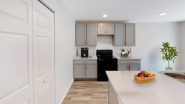 532 Piedmont St, Lehigh Acres, FL 33974 - kitchen with gray cabinetry, black range with electric stovetop, light wood-style flooring, light countertops, and recessed lighting