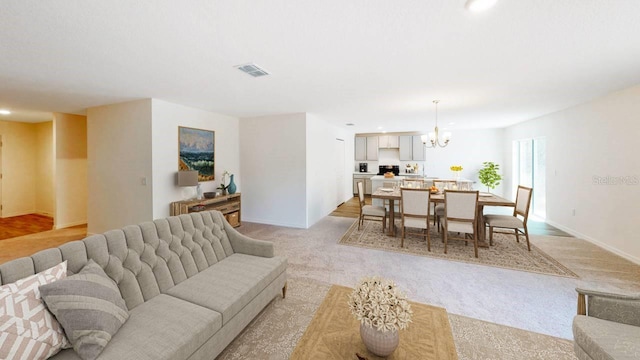 carpeted living room featuring a chandelier