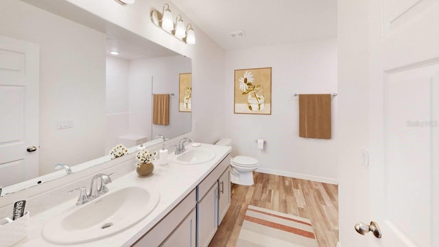 bathroom featuring vanity, wood-type flooring, and toilet