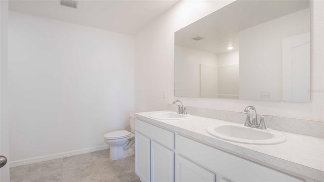 bathroom with tile patterned flooring, vanity, and toilet