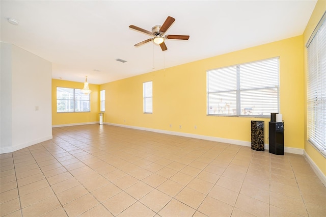 tiled spare room featuring ceiling fan