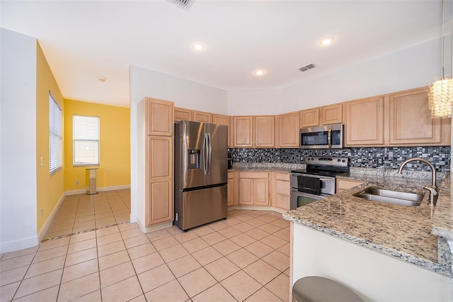 kitchen with light tile patterned flooring, sink, light brown cabinets, appliances with stainless steel finishes, and light stone countertops