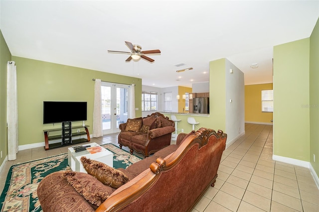 tiled living room with french doors and ceiling fan