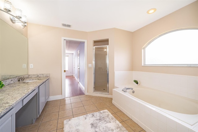 bathroom with tile patterned floors, plus walk in shower, and vanity