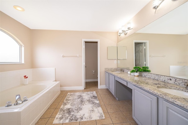 bathroom featuring vanity, a relaxing tiled tub, and tile patterned floors