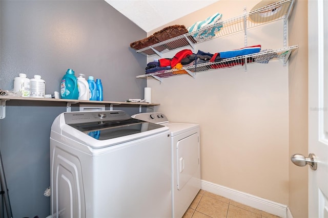 laundry area with light tile patterned floors and washing machine and clothes dryer